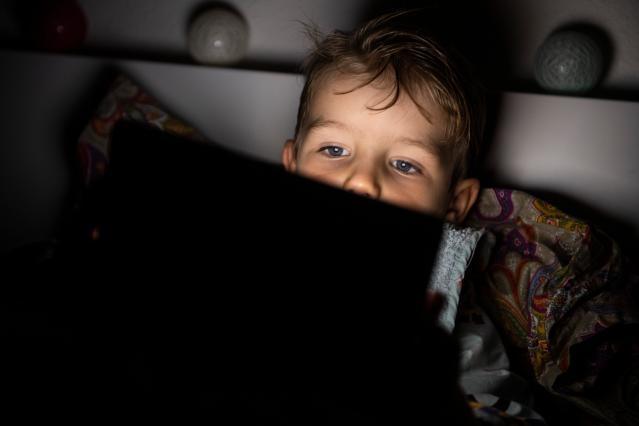 A child in bed with a tablet